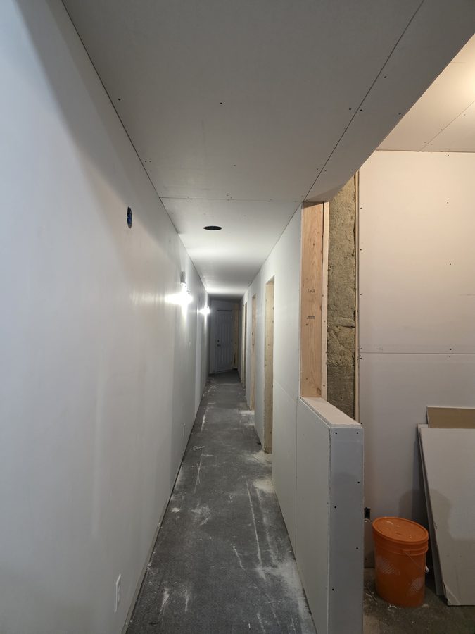 Chinook Glow drywall — corridor fully drywalled both walls