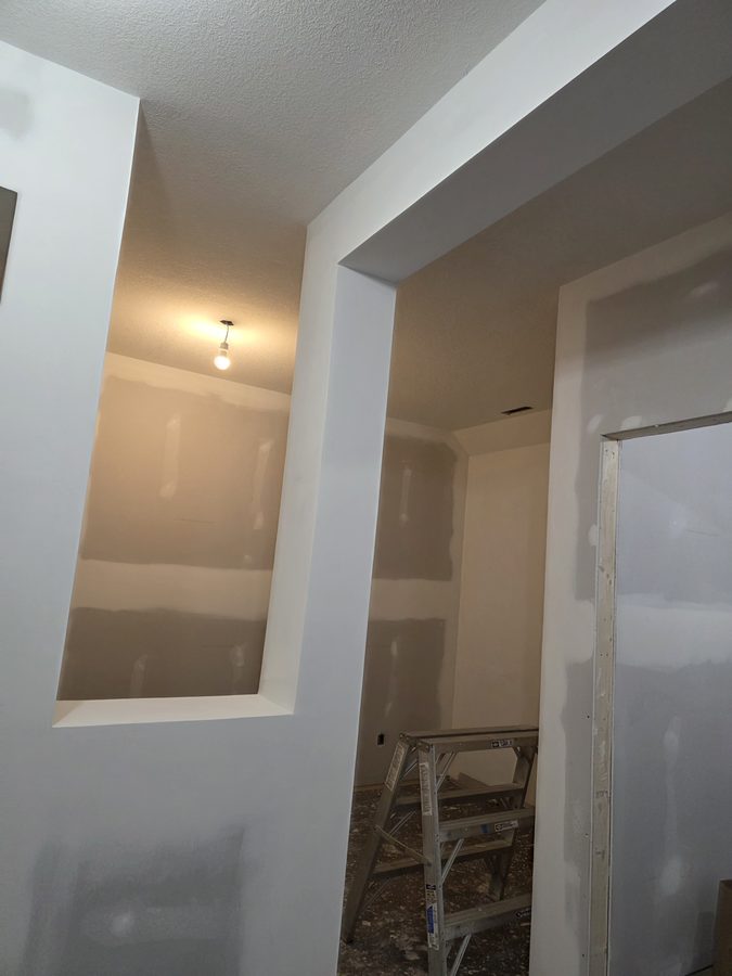 Chinook Glow drywall complete — reception pass-through windows from inside