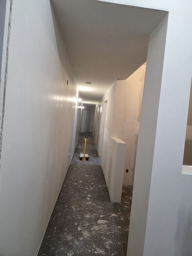 Chinook Glow drywall complete — corridor full length view primed