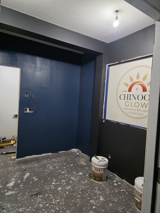 Chinook Glow paint — service room in navy with reception logo beyond