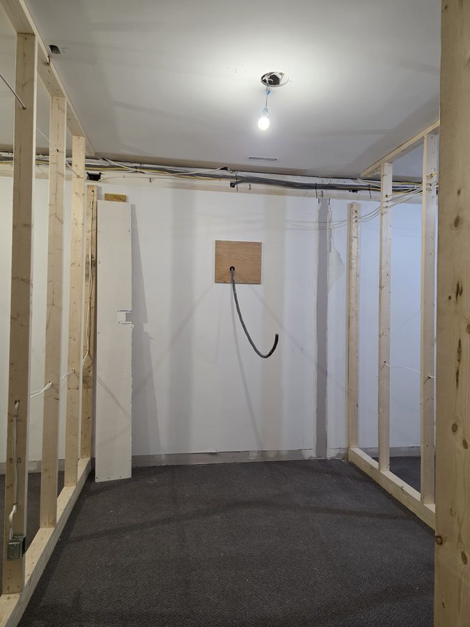 X8 tanning room before — framed walls with buck booster feed roughed in